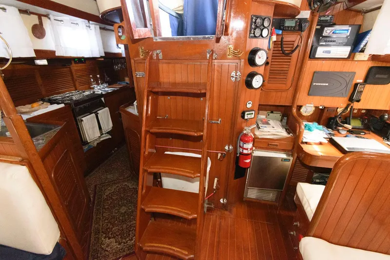 Slide: The Image of Interior of 1988 Tayana 52 sailboat with wooden stairs, galley, and navigation station. - 39