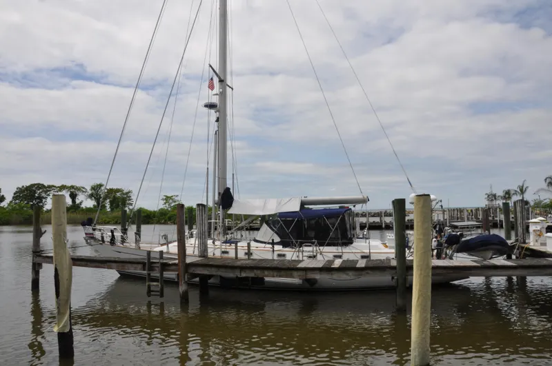 Slide: The Image of 1988 Tayana 52 sailboat docked at a marina on a cloudy day. - 6