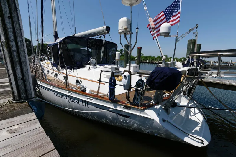 Slide: The Image of 1988 Tayana 52 sailboat docked at a marina with an American flag. - 7