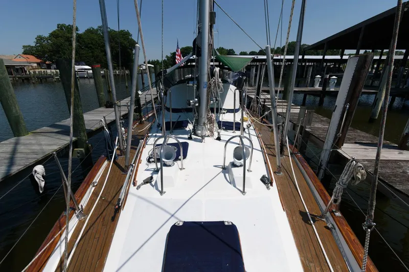 Slide: The Image of 1988 Tayana 52 sailboat docked at a marina, view of the deck and rigging. - 8