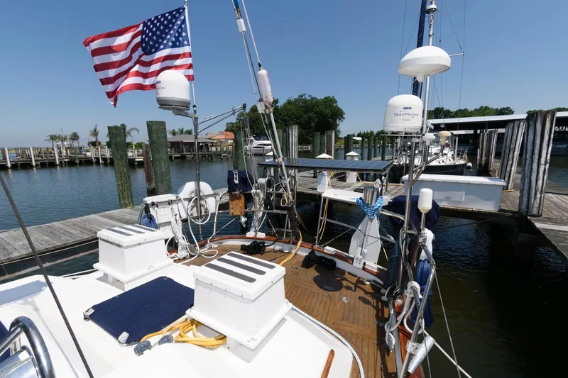 Slide: The Image of 1988 Tayana 52 sailboat docked at a marina with American flag. - 9