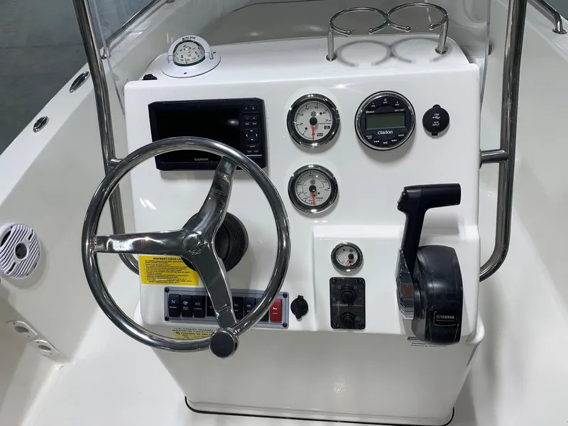 Slide: The Image of 2024 Key West 179 FS boat console with steering wheel, gauges, and controls. - 11