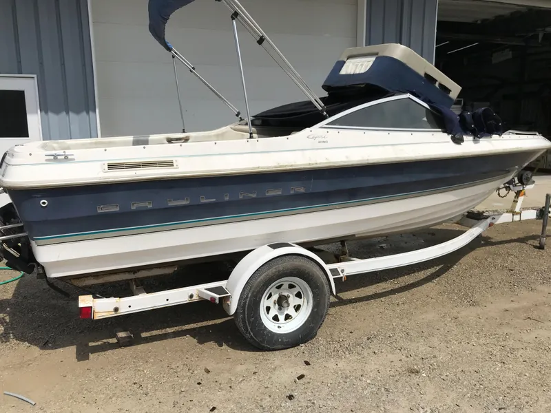 Slide: The Image of 1997 Bayliner 2050 boat on a trailer outside a garage. - 1