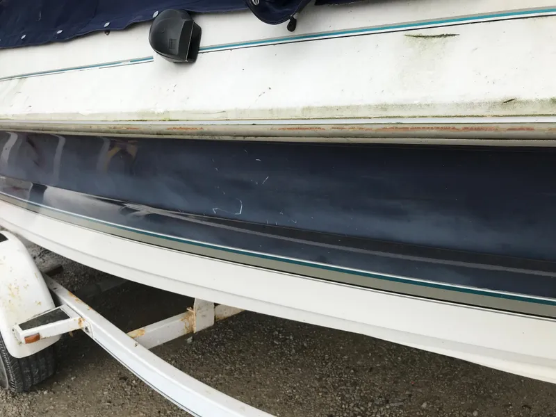 Slide: The Image of 1997 Bayliner 2050 boat hull on trailer, showing wear and dirt. - 13