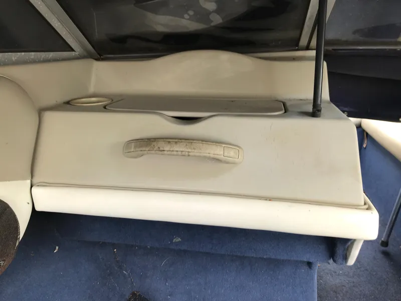 Slide: The Image of 1997 Bayliner 2050 boat interior with storage compartment and blue carpet. - 19