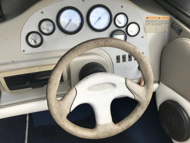 Slide: The Image of 1997 Bayliner 2050 boat dashboard with steering wheel and gauges. - 26