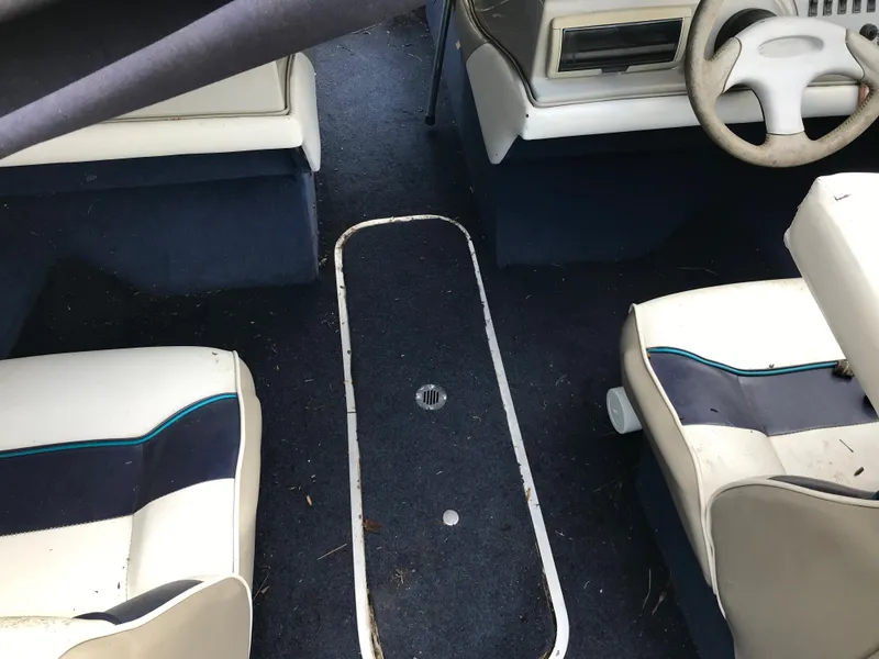 Slide: The Image of 1997 Bayliner 2050 boat interior with blue and white seating and steering wheel. - 28
