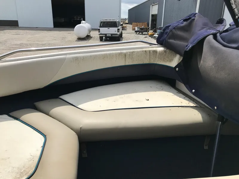 Slide: The Image of 1997 Bayliner 2050 boat interior with worn seating and cover. - 34