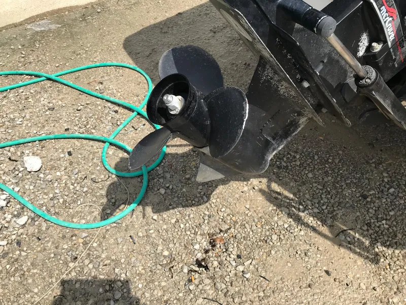 Slide: The Image of Close-up of a 1997 Bayliner 2050 boat propeller on gravel. - 40