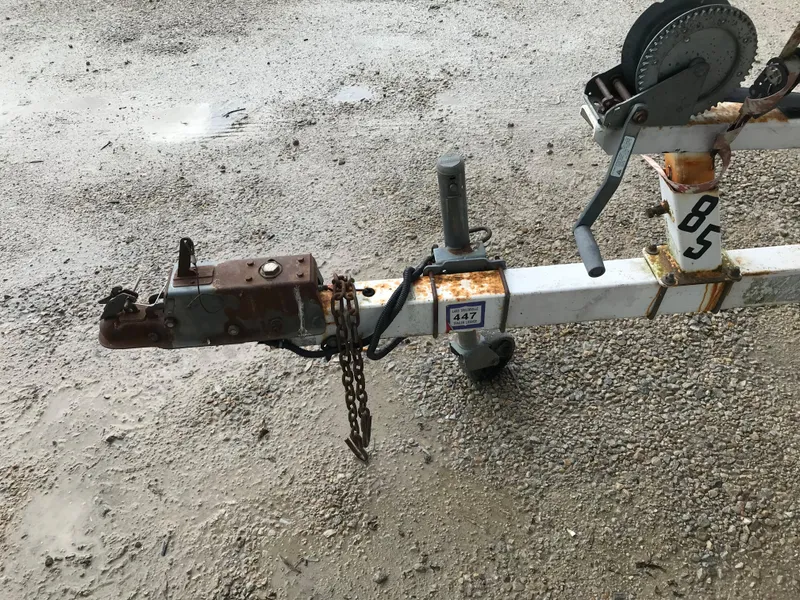 Slide: The Image of Rusty trailer hitch and winch for 1997 Bayliner 2050 boat on gravel surface. - 7