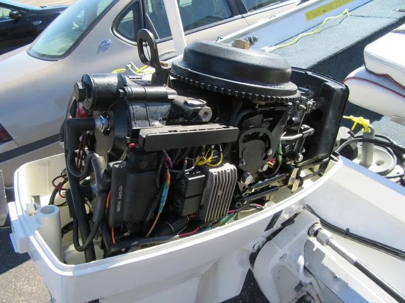 Slide: The Image of 1994 Lowe 1605 SC boat engine with open cover showing internal components. - 8