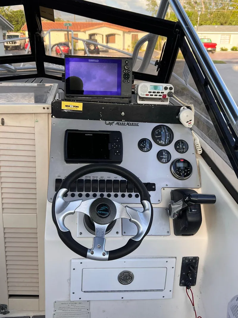 Slide: The Image of 1990 Mako 24' boat dashboard with steering wheel, gauges, and navigation equipment. - 4