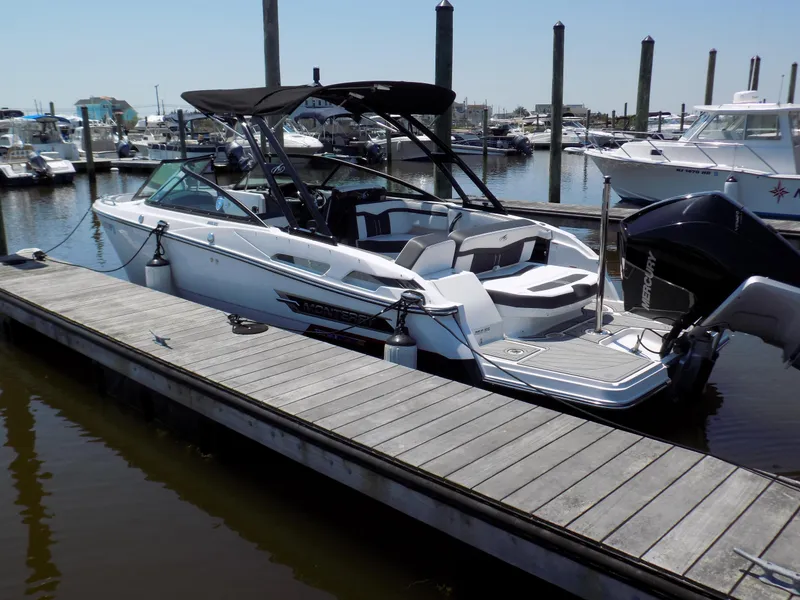 Slide: The Image of 2021 Monterey 255 Super Sport boat docked at marina, featuring sleek design and black canopy. - 1