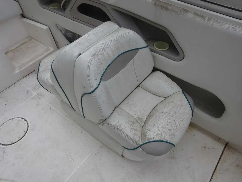 Slide: The Image of 1996 Wellcraft 2400S ECLIPSE boat interior seat, white with blue trim, showing wear. - 11