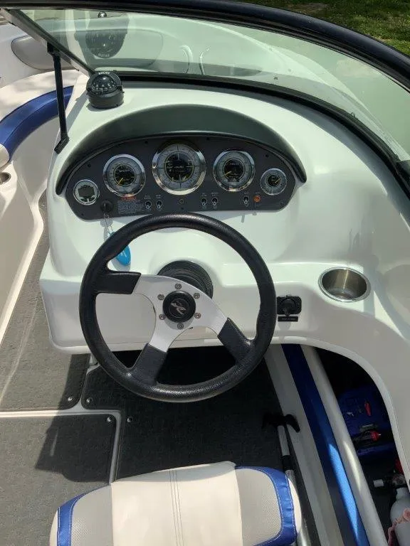 Slide: The Image of Steering wheel and dashboard of 2012 Sea Ray 205 Sport boat, featuring gauges and compass. - 3