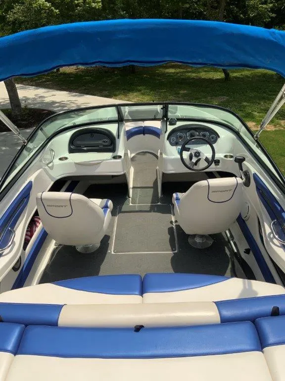Slide: The Image of 2012 Sea Ray 205 Sport boat interior with blue and white seating, under a blue canopy. - 5