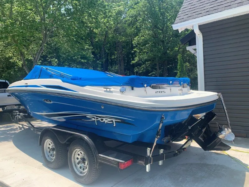 Slide: The Image of 2012 Sea Ray 205 Sport boat with blue cover on trailer, parked outdoors. - 9