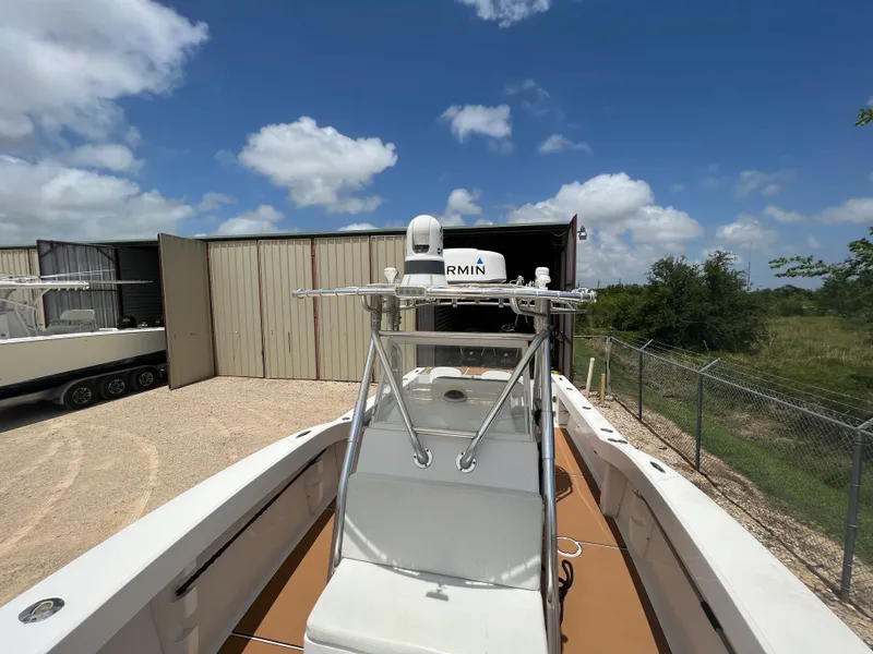 Slide: The Image of 2012 Ocean Master 336 CC boat docked near storage buildings under a clear blue sky. - 11