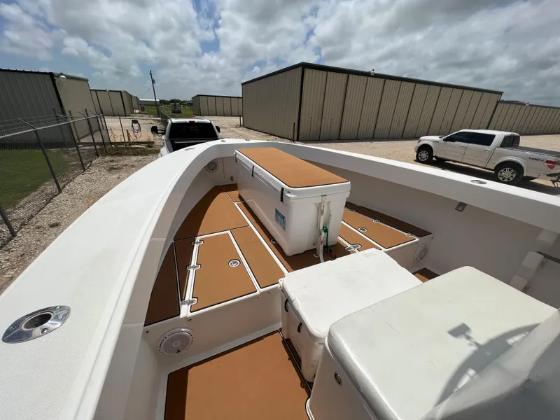 Slide: The Image of 2012 Ocean Master 336 CC boat with spacious deck, parked near storage units. - 12