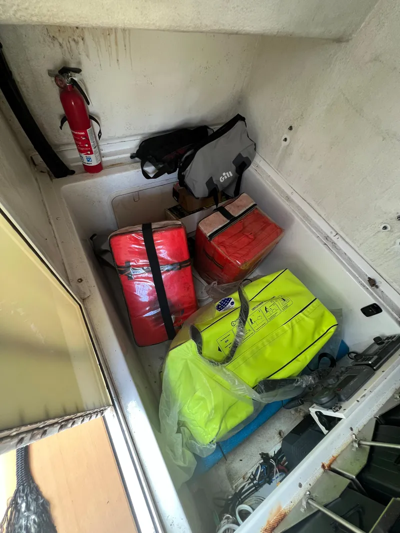 Slide: The Image of Storage compartment on a 2012 Ocean Master 336 CC boat with safety gear and fire extinguisher. - 16
