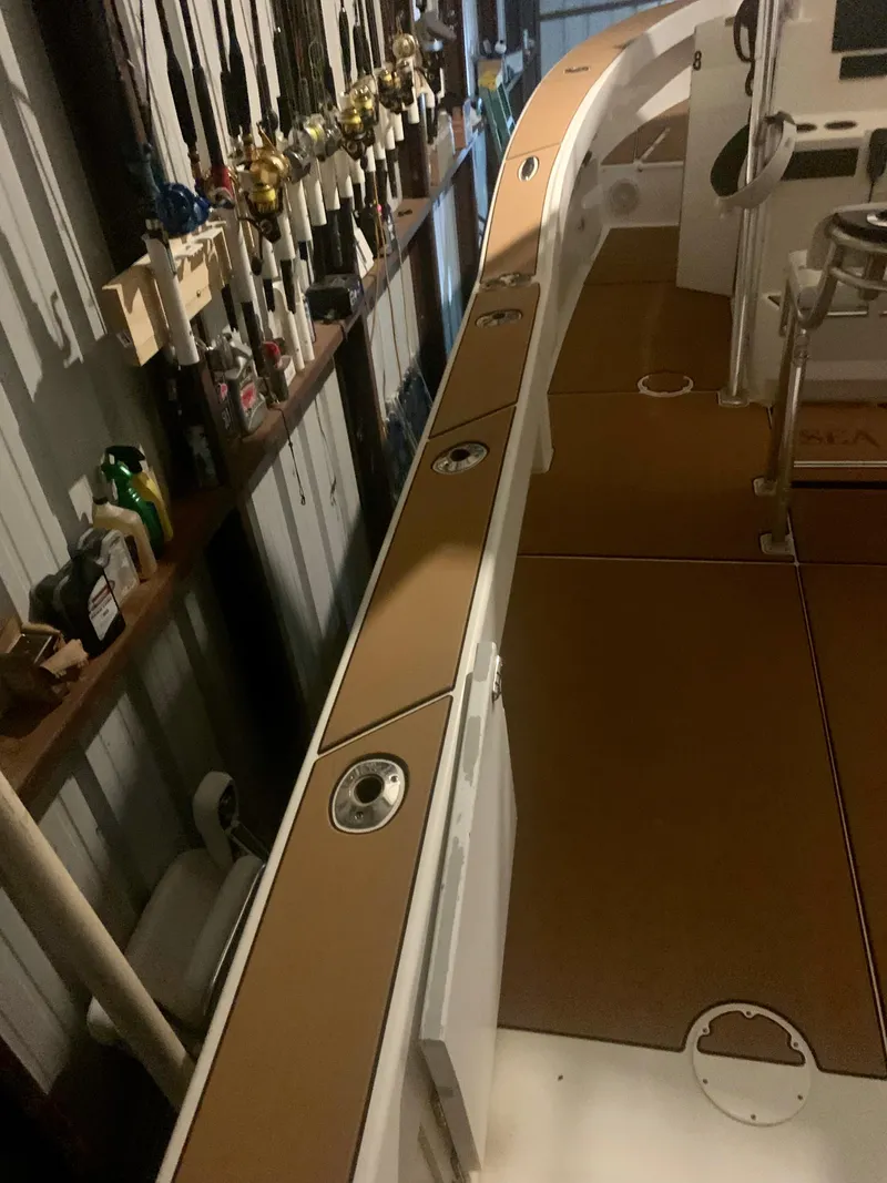 Slide: The Image of 2012 Ocean Master 336 CC boat interior with fishing rod holders and storage compartments. - 21