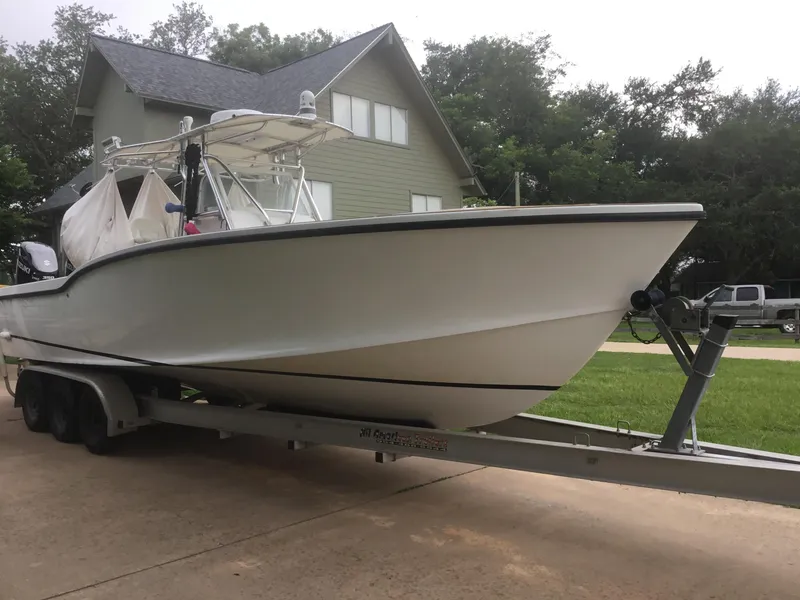 Slide: The Image of 2012 Ocean Master 336 CC boat on trailer, parked near a house. - 23