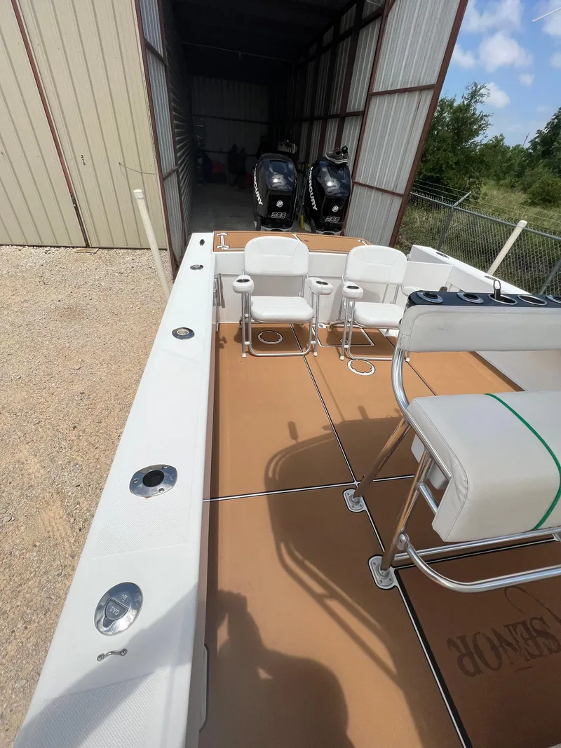 Slide: The Image of 2012 Ocean Master 336 CC boat with spacious deck and seating, stored in a covered area. - 5