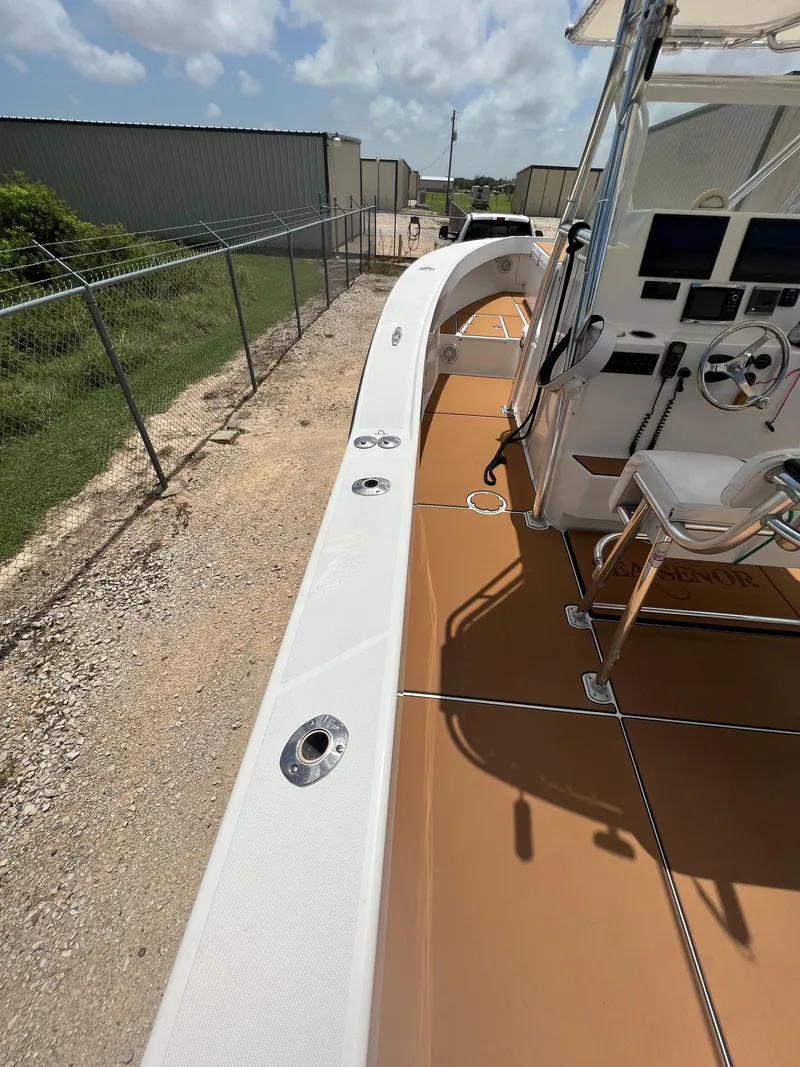 Slide: The Image of 2012 Ocean Master 336 CC boat with spacious deck and modern controls, docked outdoors. - 8