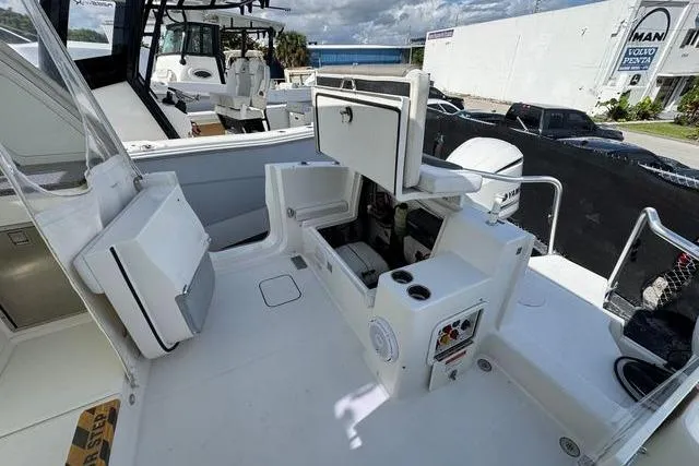 Slide: The Image of 2019 World Cat 320 DC boat interior with open storage compartments and seating area. - 16