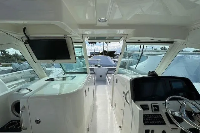 Slide: The Image of 2019 World Cat 320 DC boat interior with modern dashboard and seating area. - 23