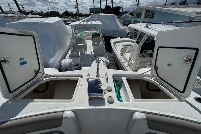 Slide: The Image of 2019 World Cat 320 DC boat with open storage compartments and visible seating area. - 25