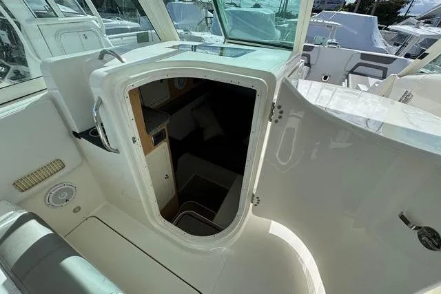 Slide: The Image of 2019 World Cat 320 DC boat interior cabin entrance with seating and storage. - 27