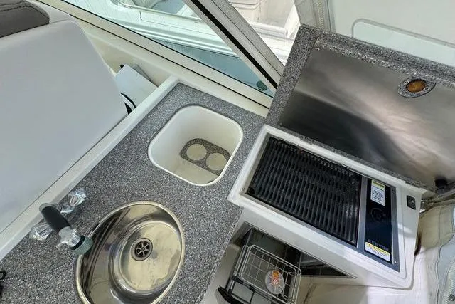 Slide: The Image of Compact boat kitchenette with sink, grill, and storage on a 2019 World Cat 320 DC. - 28