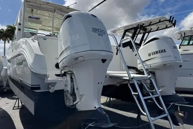 Slide: The Image of 2019 World Cat 320 DC boat with twin Yamaha 300 HP engines, docked under cloudy sky. - 33