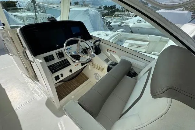 Slide: The Image of Cockpit of 2019 World Cat 320 DC boat with modern controls and steering wheel. - 34