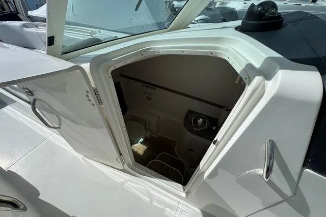 Slide: The Image of 2019 World Cat 320 DC boat interior cabin with open door, showcasing compact design. - 40