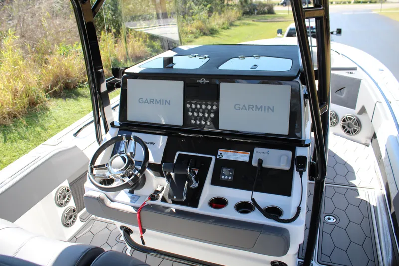 Slide: The Image of 2023 Fountain 34 SC boat cockpit with Garmin navigation displays and modern controls. - 12