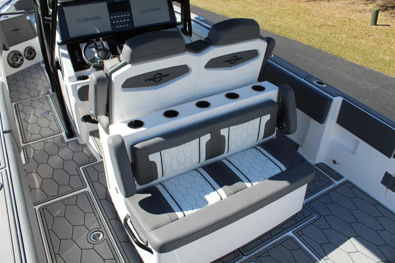 Slide: The Image of 2023 Fountain 34 SC boat interior with modern seating and hexagonal flooring design. - 14