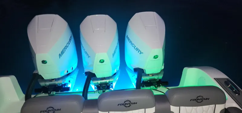 Slide: The Image of 2023 Fountain 34 SC boat with triple Mercury engines illuminated at night. - 23