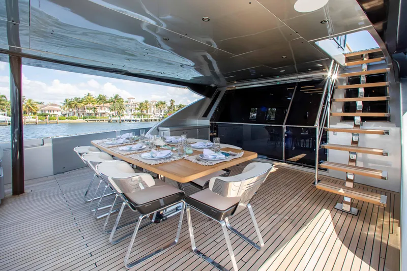Slide: The Image of Luxurious 2014 Riva Mythos Motoryacht deck with elegant dining setup and scenic waterfront view. - 34
