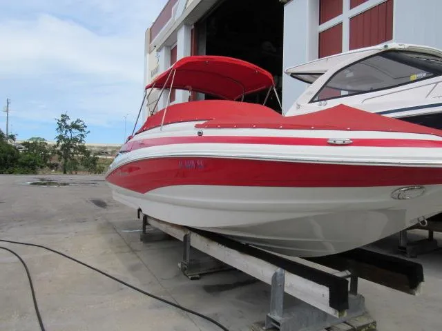 Slide: The Image of 2016 Crownline 255 SS boat with red and white exterior in storage. - 3