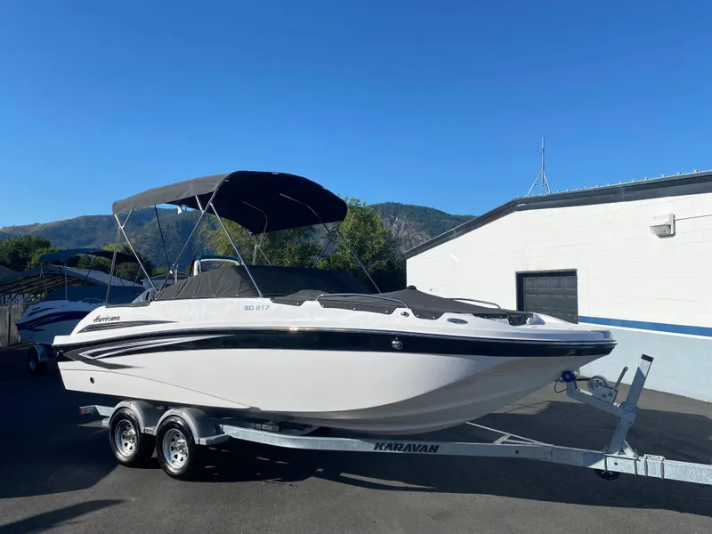 Slide: The Image of 2022 Hurricane SD217OB boat on a trailer with a black canopy. - 2