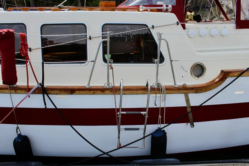 Slide: The Image of Side view of a 1981 Skookum 53 boat with red and white detailing. - 12