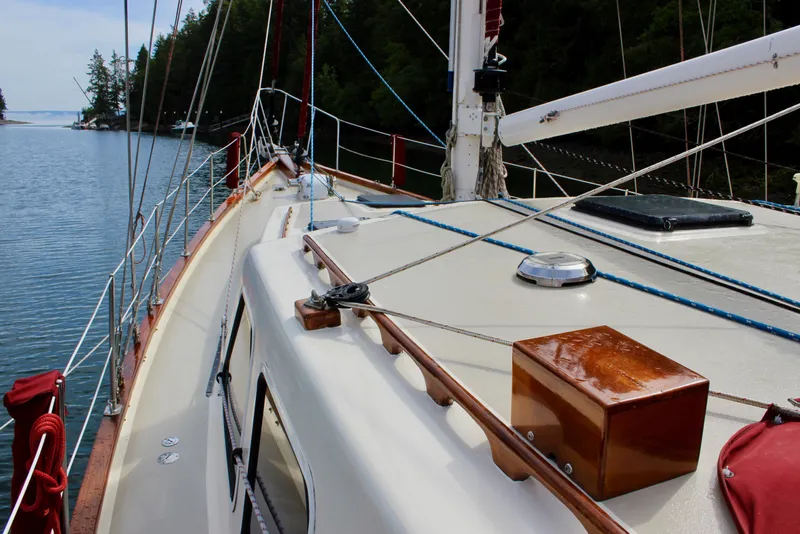 Slide: The Image of Sailboat deck view of 1981 Skookum 53, moored in a serene forested inlet. - 13
