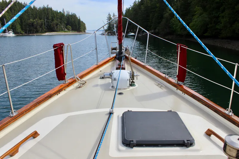Slide: The Image of Deck view of 1981 Skookum 53 sailboat, surrounded by serene waters and lush greenery. - 15