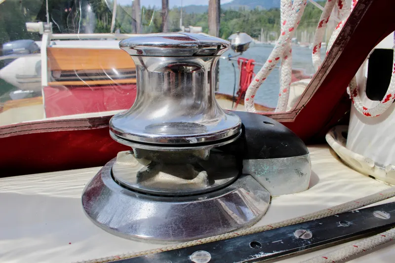 Slide: The Image of Chrome winch on 1981 Skookum 53 sailboat deck, surrounded by ropes. - 48