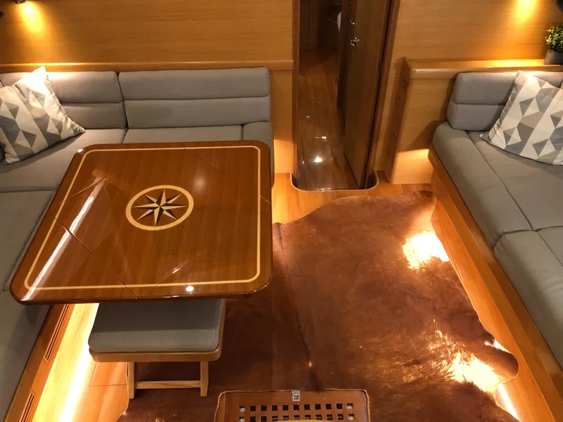 Slide: The Image of Luxurious interior of 2020 Bluewater 56 yacht with elegant wood table and plush seating. - 38