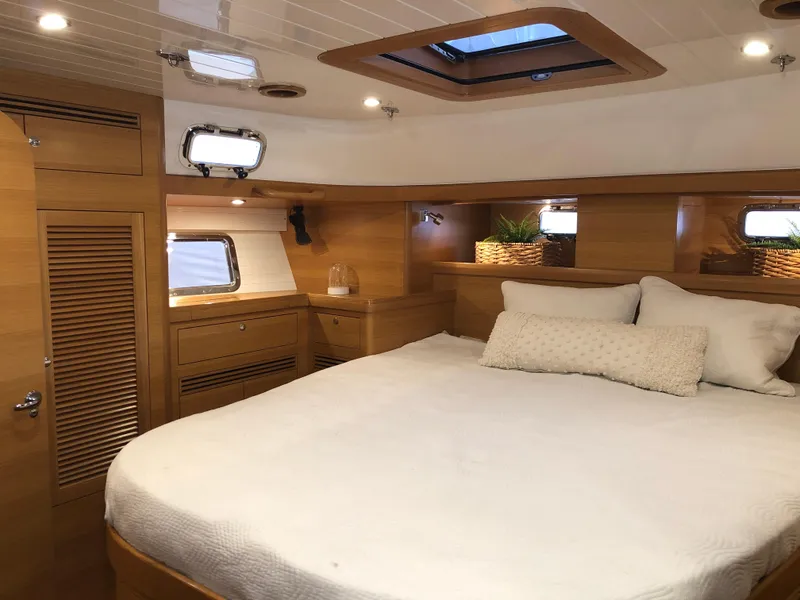 Slide: The Image of Luxurious cabin interior of 2020 Bluewater 56 yacht with cozy bed and wooden finish. - 46