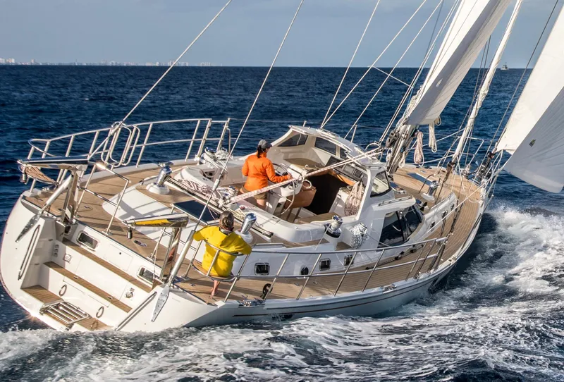 Slide: The Image of Sailing yacht Bluewater 56, 2020 model, navigating ocean waves with crew on deck. - 7