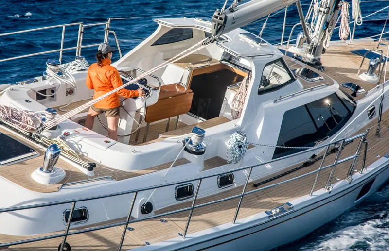Slide: The Image of 2020 Bluewater 56 yacht sailing with person on deck in vibrant ocean setting. - 8